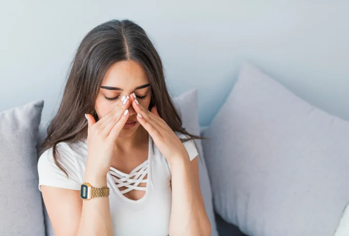 woman holding her nose because sinus pain