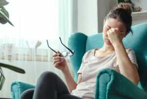 Young Woman with Eyeglasses Suffers Eye Fatigue